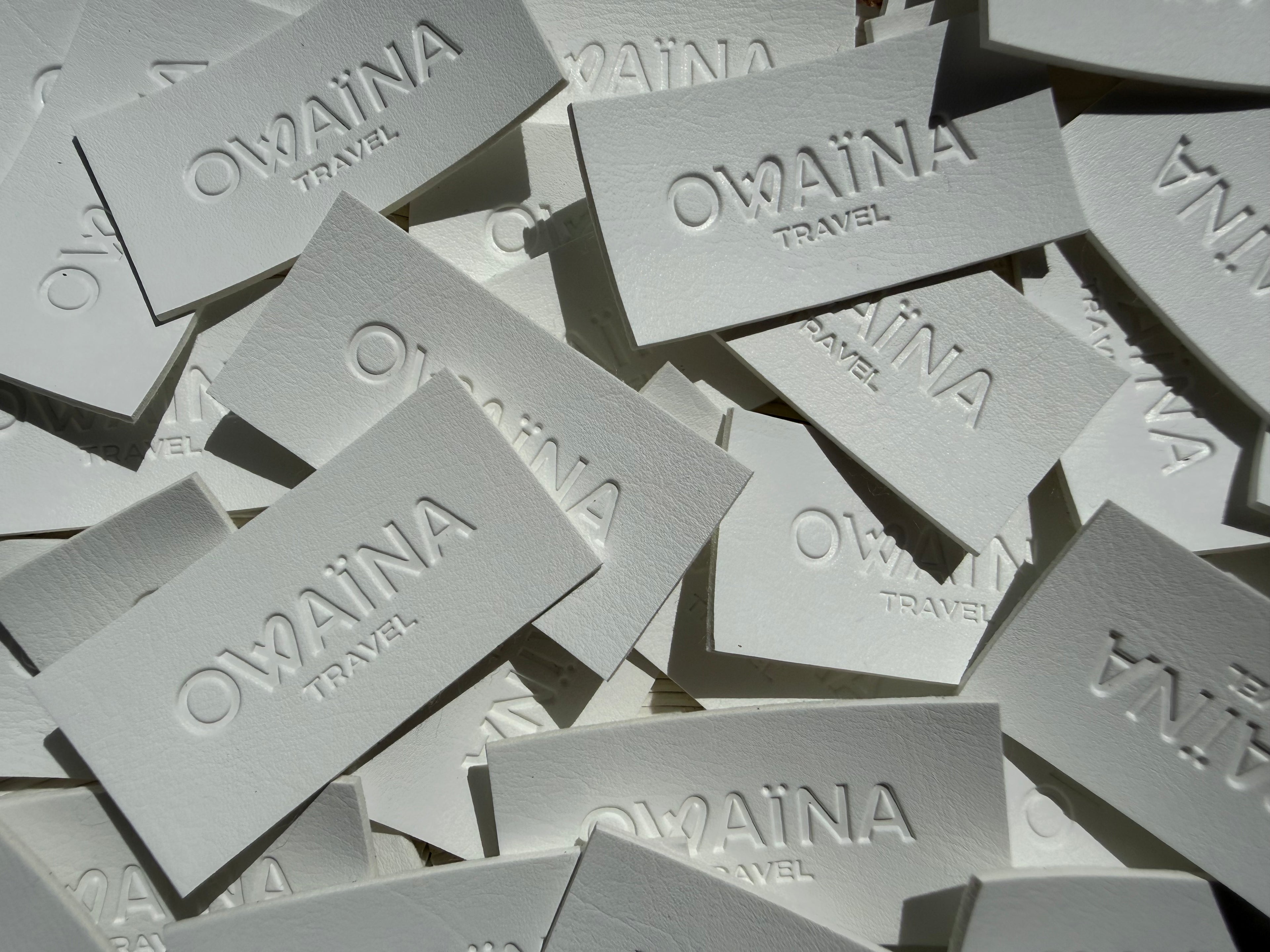 Superposition d'étiquettes de marque Owaïna dans un plateau.