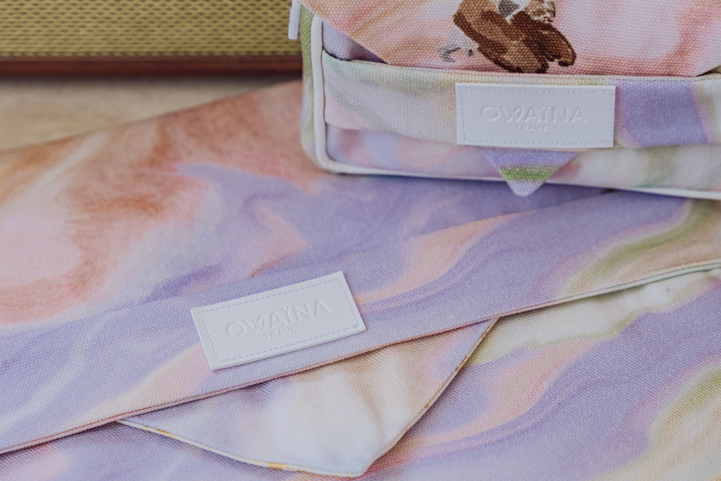 Zoom sur accessoires de voyage Owaïna, la trousse à chargeurs et la housse à ordinateur.