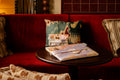 Duo housse ordinateur et trousse à chargeurs sur table salon hôtel.