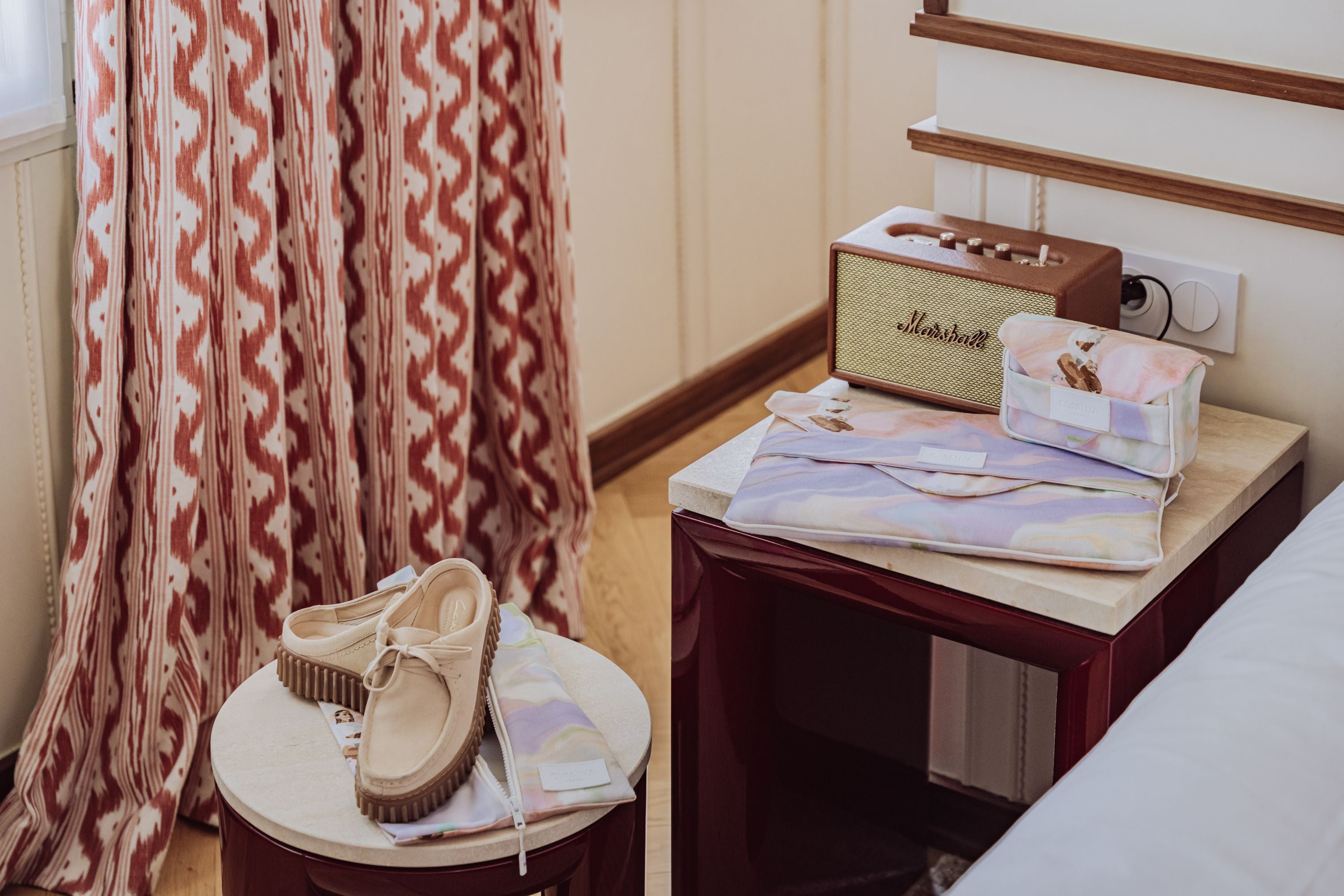 Pack de trois accessoires de voyage pour femme, pour leur faciliter les voyages business. Ranger son ordinateur, ses chargeurs, et ses chaussures. Accessoires business disposé dans une chambre d'hôtel luxueuse et lumineuse. 