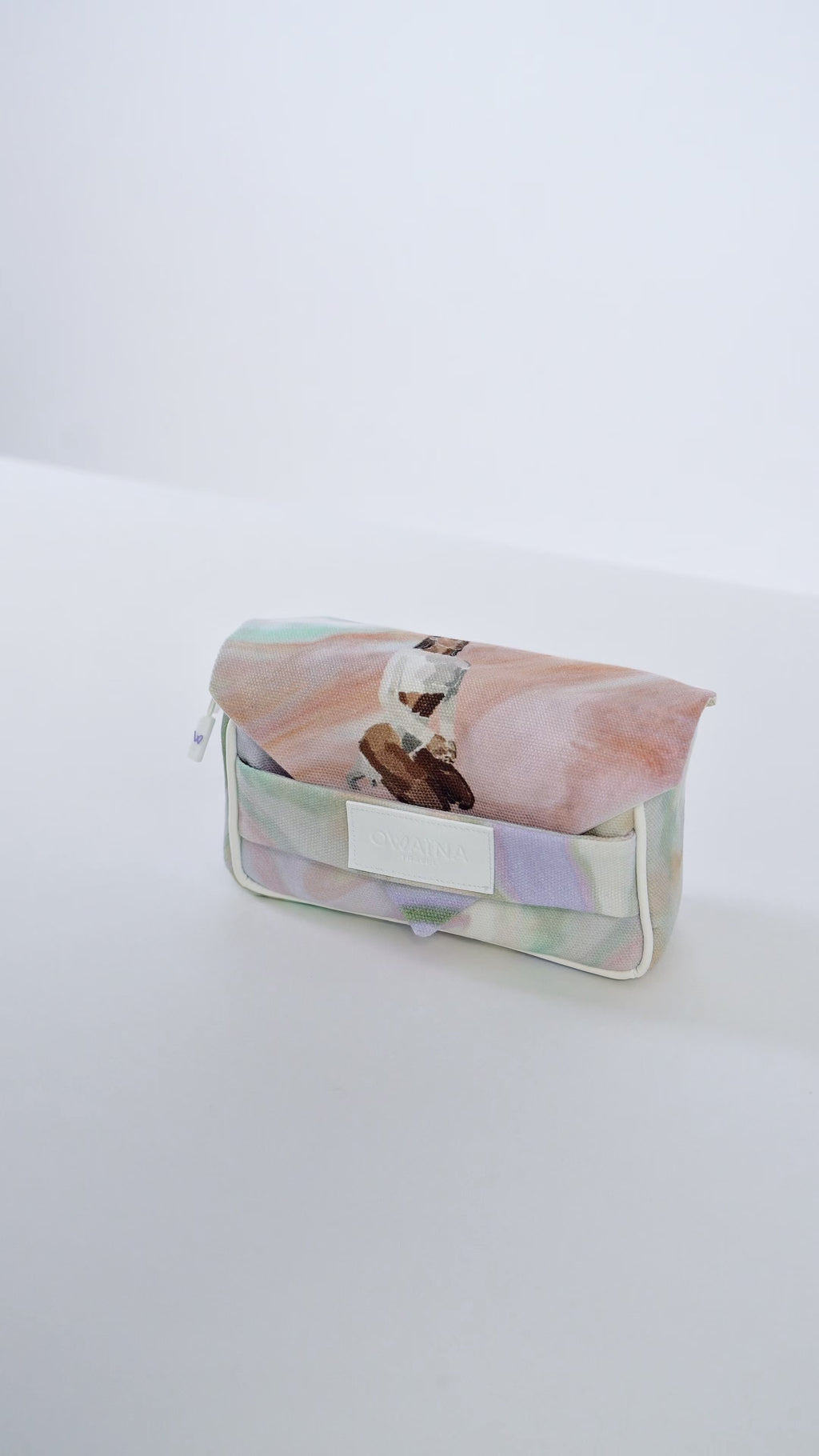 Vidéo trousse à chargeurs avec double compartiments Owaïna aux motifs pastel artistiques présentées sur fond blanc.