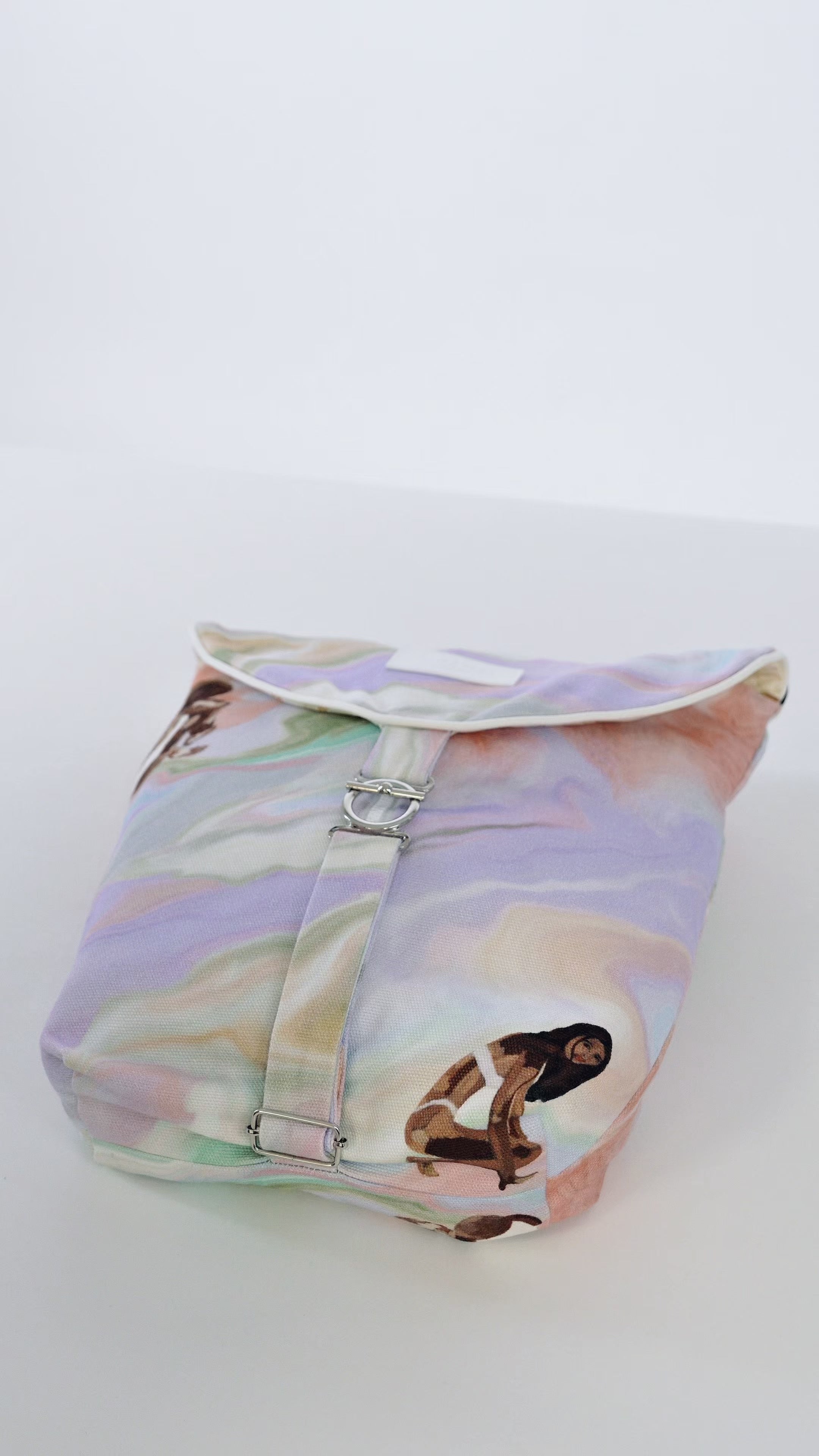 Vidéo sac à vêtements de voyage Owaïna pastel avec rabat arrondi et fermoir métallique argenté, présenté en duo sur fond blanc minimaliste.