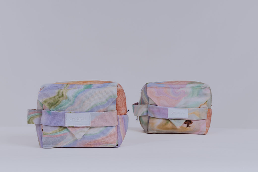Trousses de toilette à compartiments pastel Owaïna avec fermeture zippée sur fond blanc